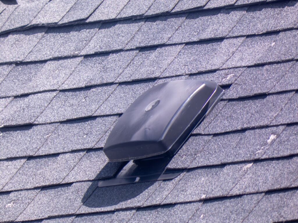 A roofing vent on a modern shingled roof