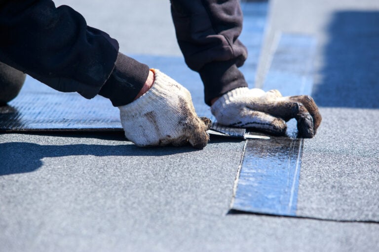 Worker cuts roofing material