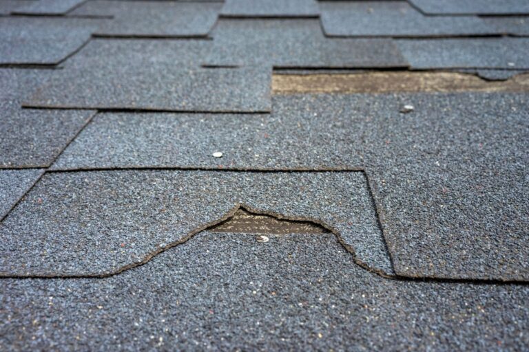 Close up view of bitumen shingles roof damage that needs repair