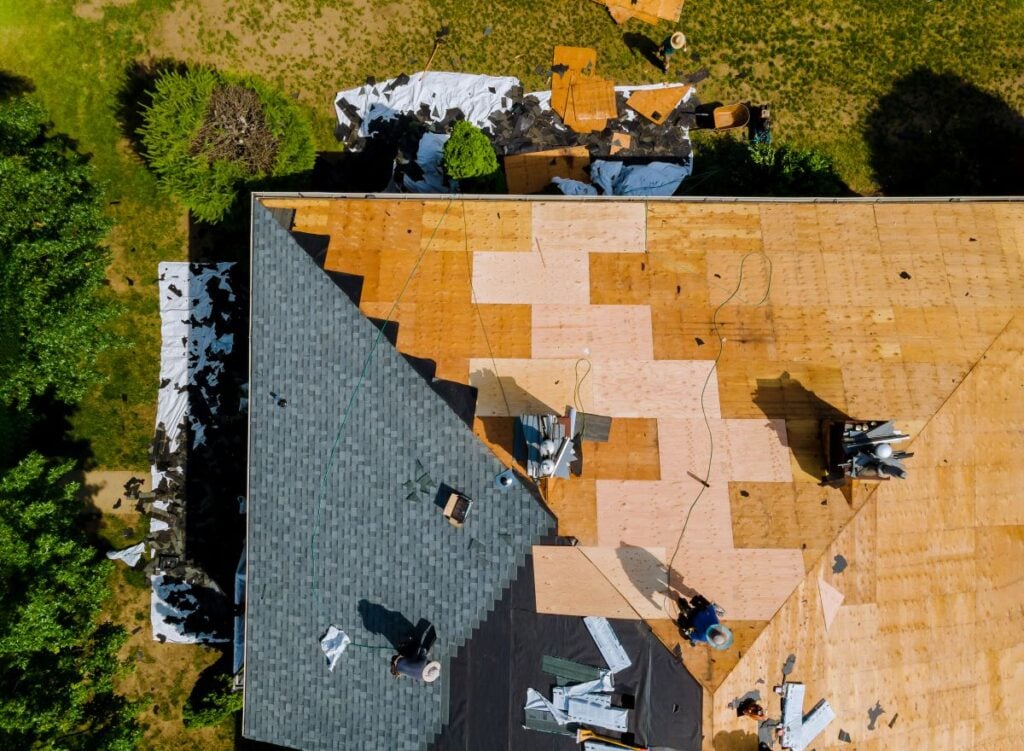 Home with roof replacing new shingles, felt paper, and tools