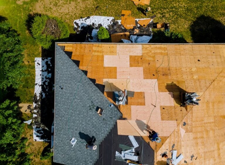Home with roof replacing new shingles, felt paper, and tools