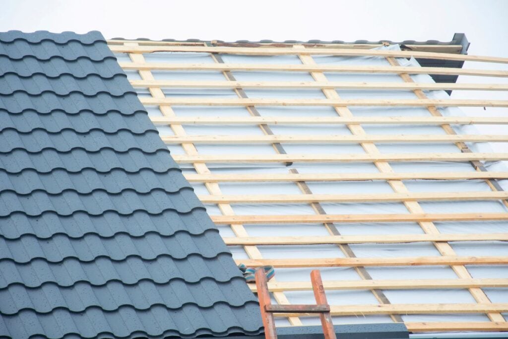 Repairs roof replacement. Removal of old roof and replacement with all new materials. Roof construction site. Metal roofing.