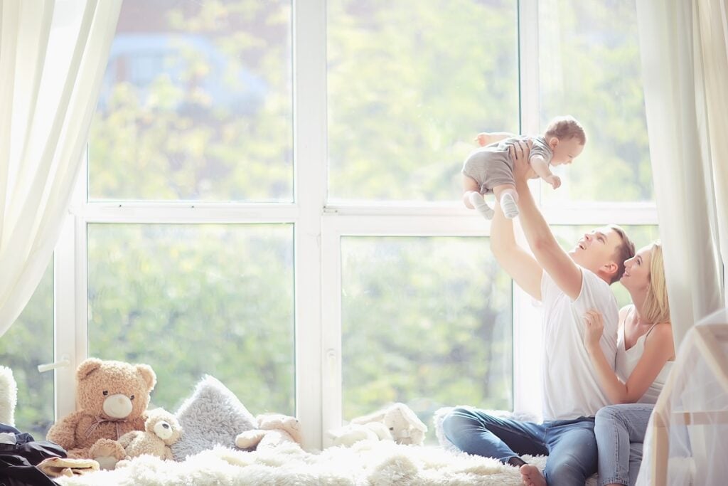 family sitting in front of large windows