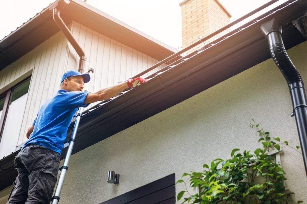 man cleaning out gutters