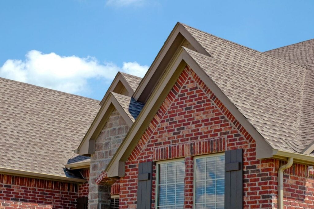red brick house with grey shingles on the roof