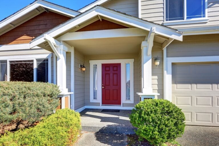 Entrance porch with red front door. House exterior.